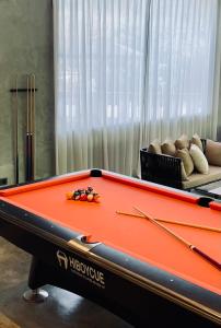 a pool table in a living room with two cues at BaBa Boutique House Langkawi in Pantai Cenang