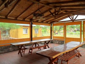 un patio con 2 bancos y una mesa y ventanas en Cabañas Mandala, en San Marcos Sierras