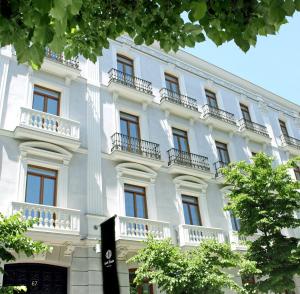 ein großes weißes Gebäude mit Fenstern und Balkonen in der Unterkunft Hotel Único Madrid, Small Luxury Hotels in Madrid