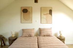 a bed in a bedroom with two pictures on the wall at Maison Magnifiek in Hasselt