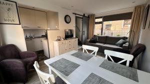 a kitchen and a living room with a table and chairs at Beach-house27 in Egmond aan Zee