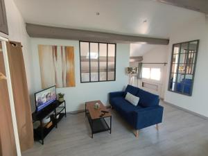 a living room with a blue couch and a tv at Magnifique Studio à Manosque in Manosque