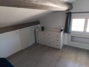 an attic room with a dresser and a window at Magnifique Studio à Manosque in Manosque