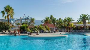 a swimming pool in a resort with people in the water at Argeles Mobil'holidays del mar camping 222 in Argelès-sur-Mer