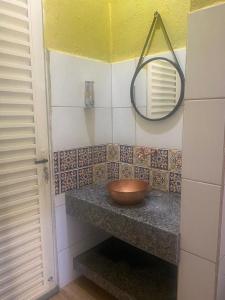 a bathroom with a bowl on a counter with a mirror at CHALÉS MARICOTA in Vargem Bonita +46 photos