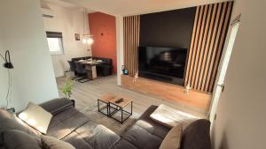 a living room with a couch and a flat screen tv at Hiša Ispira in Moravske-Toplice