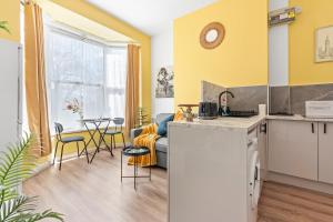 cocina y sala de estar con paredes amarillas en Cosy entire flat 5 min from Citycentre sleeps 4, en Birmingham