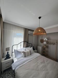 a bedroom with a large white bed and a chandelier at Nills butik otel in Bozcaada