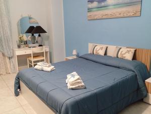 Un dormitorio con una cama azul con toallas. en Nonna Lella's House, en Agrigento