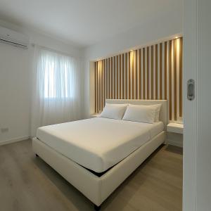 a white bed in a bedroom with a window at AR Palace Hotel - Palermo in Isola delle Femmine