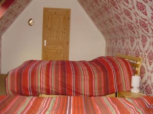 a bedroom with a bed with a red striped sheet at Au jet de pierre in Saint-Inglevert
