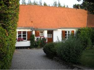 a small white house with an orange roof at Au jet de pierre in Saint-Inglevert