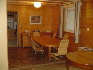 a dining room with a wooden table and chairs at Au jet de pierre in Saint-Inglevert