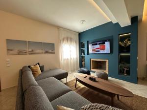 a living room with a couch and a tv at Villa Isidora Luxe in Kalívia Thorikoú