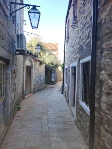 布德瓦Apartman Kaprize的一条拥有石头建筑和街灯的小巷
