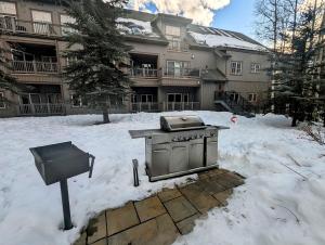a grill in the snow in front of a building at Expedition Station 8622 by SummitCove Lodging in Keystone