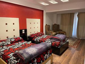 a bedroom with two beds and a red wall at Water-Front-Porto in Ain Sokhna