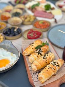 a table topped with plates of pastries and bowls of food at Nills butik otel in Bozcaada