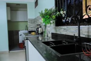 a kitchen with a sink and a counter top at Le Bungalow Juane in Kampala