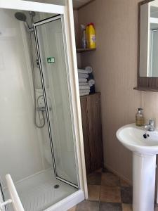 a bathroom with a shower and a sink at Combe Haven in Hastings