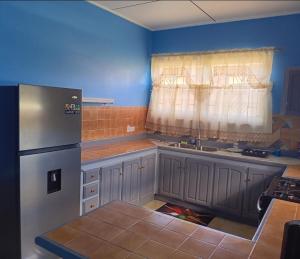 Una cocina con refrigerador de acero inoxidable y ventana. en Michael's Beach Complex #3, en Brighton Village