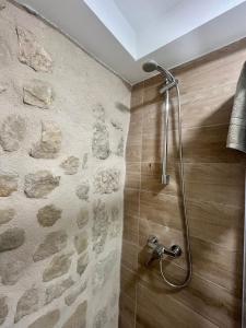 a shower in a bathroom with a stone wall at Apartamentos Rurales Miguela in Calaceite +22 photos