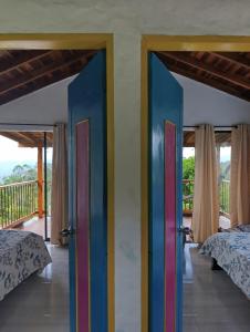 Cette chambre comprend 2 lits et 2 portes colorées. dans l'établissement La cabaña - Finca los Martinez, à Támesis