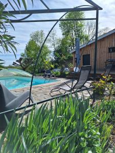 a group of chairs sitting next to a swimming pool at Lodge les ombelles in Coutras +10 photos