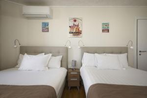 two beds sitting next to each other in a room at Hotel des Congrès et Festivals in Cannes