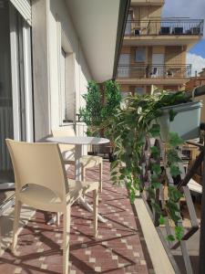 un patio con tavolo e sedie su un balcone di Due passi dal mare a Bellaria-Igea Marina