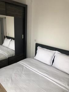 a bedroom with two beds and a mirror at Apartament za gosti Zlatograd in Zlatograd