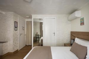 a bedroom with a white bed and a mirror at Hotel des Congrès et Festivals in Cannes