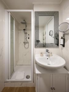 a white bathroom with a sink and a shower at Hotel des Congrès et Festivals in Cannes