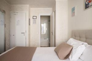 a bedroom with a white bed and a bathroom at Hotel des Congrès et Festivals in Cannes