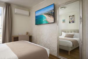 a hotel room with a bed and a mirror at Hotel des Congrès et Festivals in Cannes