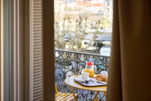 a table with a plate of food on a balcony at Hotel des Congrès et Festivals in Cannes