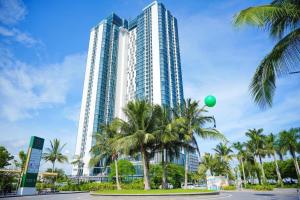a tall building with palm trees and a green balloon at A La Carte Ha Long Oceanview Fireworksview 2BR2WC suite with balcony in Ha Long