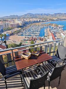 a table on a balcony with a view of a harbor at La Bella Vista in Puerto de Mazarrón