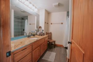 a bathroom with a sink and a large mirror at 3 King Beds Hot Tub Arcades 5 Baths in Albuquerque +46 photos