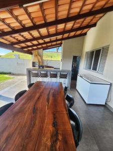 einen Holztisch und Stühle auf einer Terrasse mit einem Tisch und einer Theke in der Unterkunft Rancho paraíso verde in Capitólio