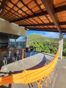 eine Hängematte auf der Terrasse eines Hauses mit Aussicht in der Unterkunft Rancho paraíso verde in Capitólio
