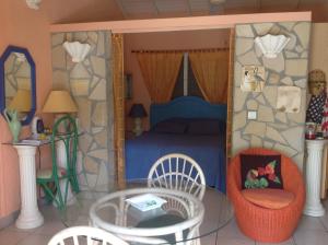 a bedroom with a bed and a table and chairs at Sun Caraibes in Orient Bay
