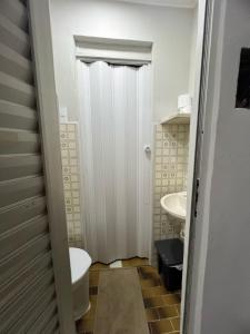 a small bathroom with a toilet and a sink at Apartamento 101 - Suíte ampla para grupos e empresas in Patos de Minas