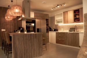 a kitchen with a counter and a kitchen island with chairs at Résidence Alissa Charleroi Airport in Charleroi