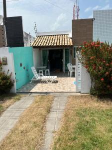 a house with a patio with chairs and flowers at Casa de praia village in Conde
