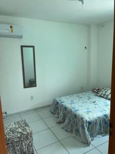 a bedroom with a bed and a mirror on the wall at Casa de praia village in Conde