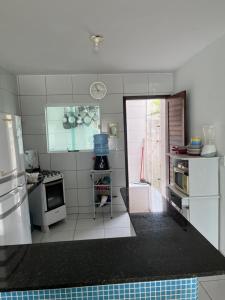 a kitchen with white appliances and a counter top at Casa de praia village in Conde