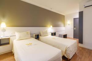 Postel nebo postele na pokoji v ubytování Uniclass Hotel Pinheiros