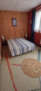 a bedroom with a bed with a wooden wall at Maison avec jardin à 150 m de la plage in La Plaine-sur-Mer