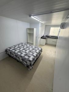 Habitación con cama en habitación blanca en Studios Canaã, en Canaã dos Carajás